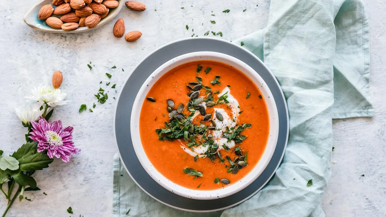 Warm bowl of garden vegetable soup with clear broth, diced carrots, celery, and fresh herbs