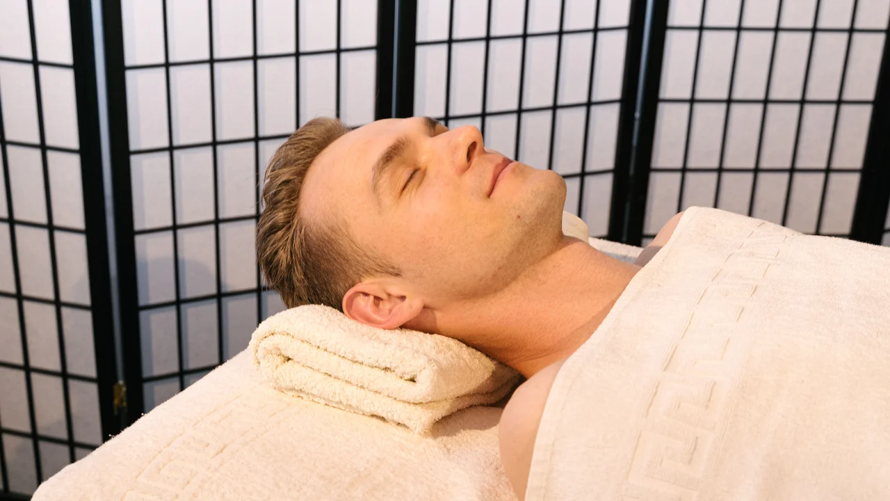 Therapist applying firm sustained deep tissue pressure to release contracted muscles and chronic myofascial tension
