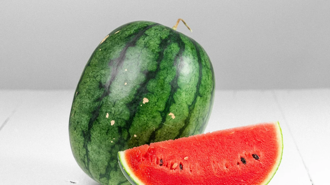 Freshly sliced ripe red watermelon wedges on white plate providing hydrating natural sweetness