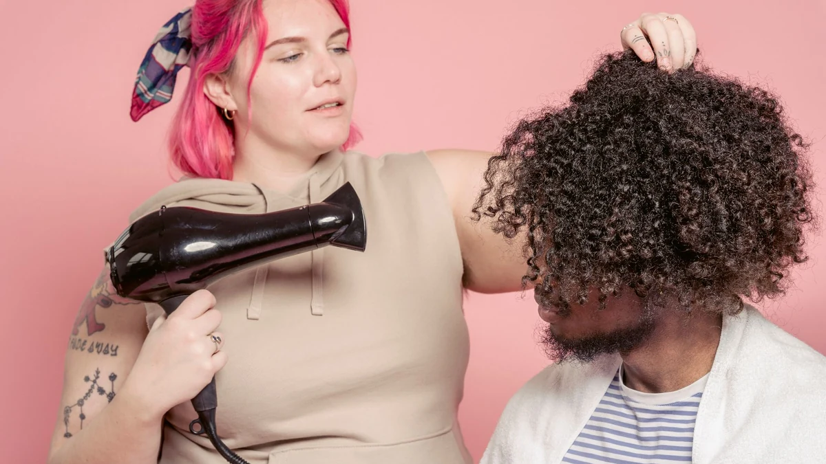 Hairstylist using hair dryer with wide bowl diffuser attachment on curly hair for indirect heat styling