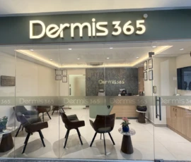 Modern illuminated glass entrance and reception area at Dermis 365 clinic