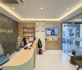 Spacious waiting lounge with comfortable seating and backlit clinic branding at Dermis 365